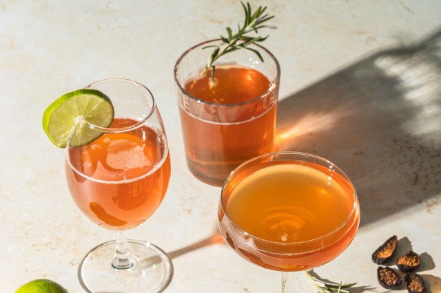 An image of three cocktail glasses with brown drinks in them