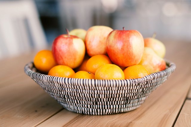 An image of a bowl of apples on a wooden table