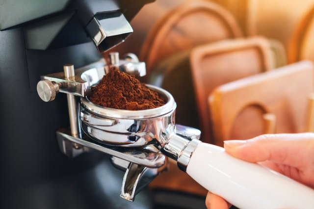 An image of a person pouring brown powder on silver cup