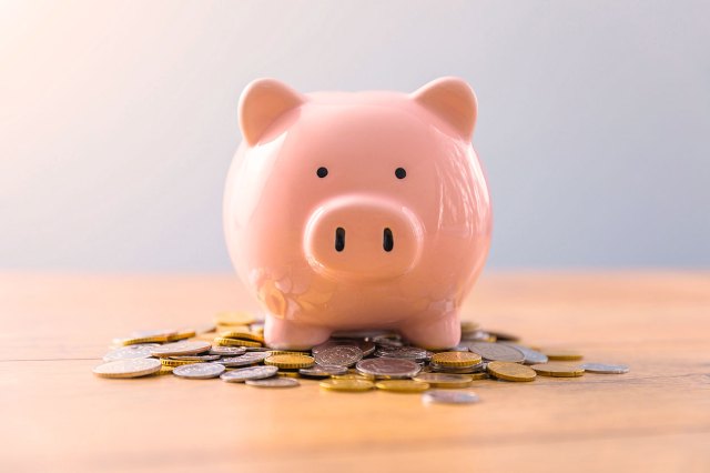 An image of a piggy bank sitting on coins