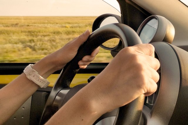 An image of hands on a steering wheel