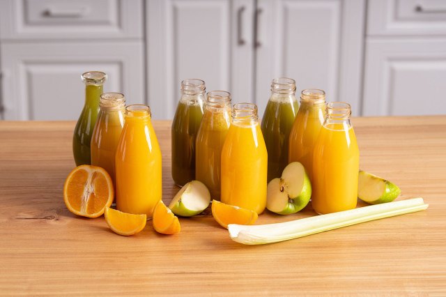 An image of bottles of pressed juices on a wooden table