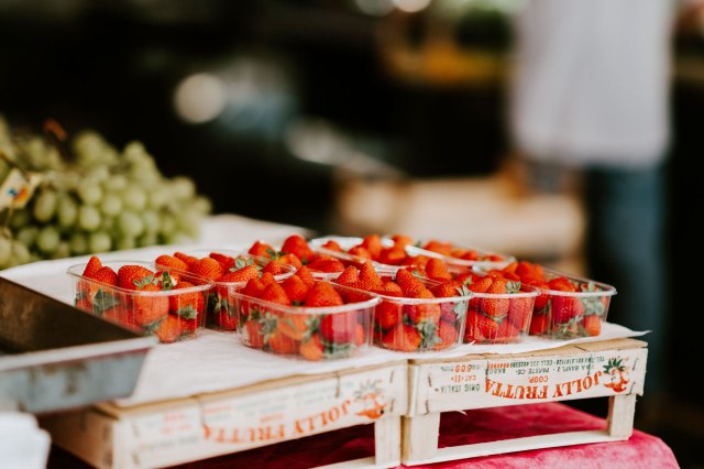 An image of pints of strawberries in a farmer's market