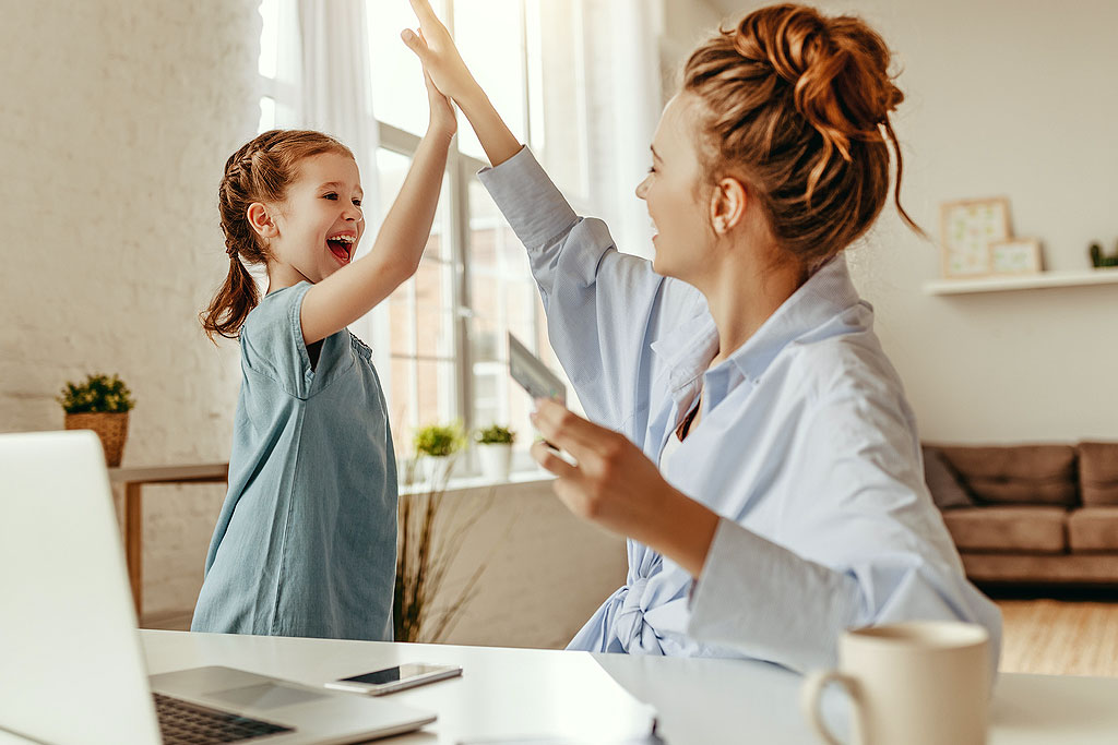 An image of a woman and a young give high-fiving