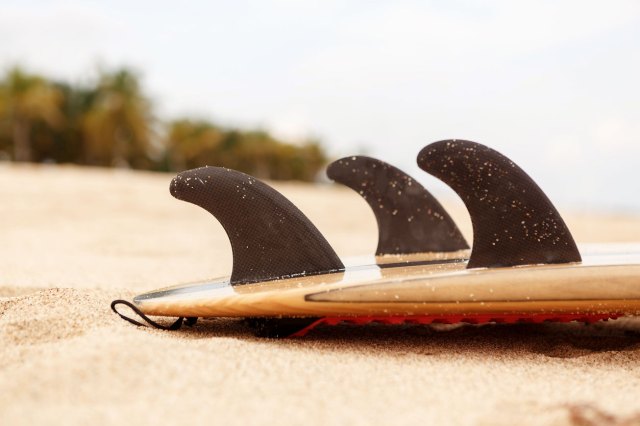 A close-up image of a surfboard on the beach