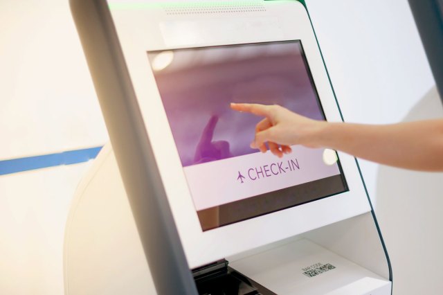 A woman uses the auto self-service check-in machine to get a boarding pass at the airport