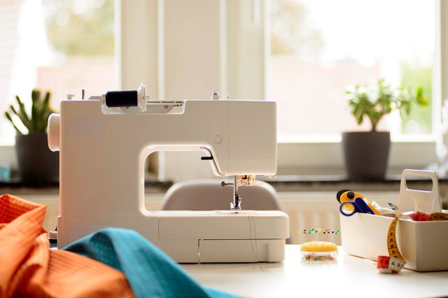 An image of a white sewing machine and sewing materials