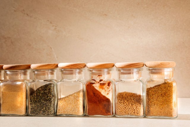 An image of a line of colorful spices in clear glass jars