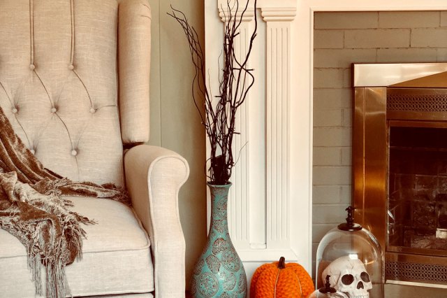 An image of pumpkins and skull decors near fireplace
