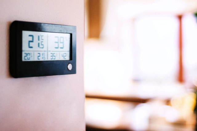 A thermostat on a pink wall