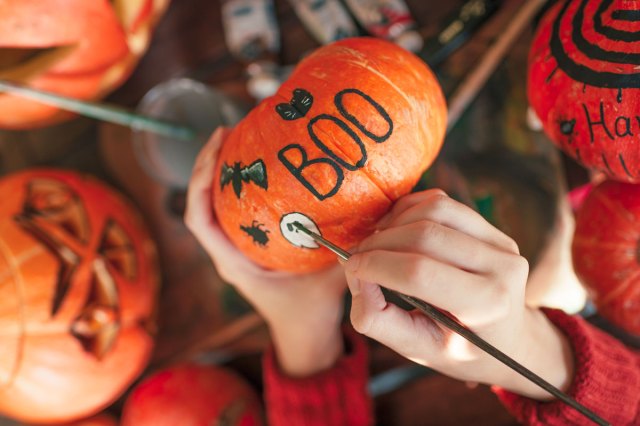 An image of a person painting a pumpkin