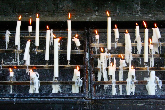 An image of lighted white pillar candles