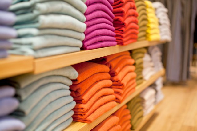 An image of colorful clothing folded on a store shelf