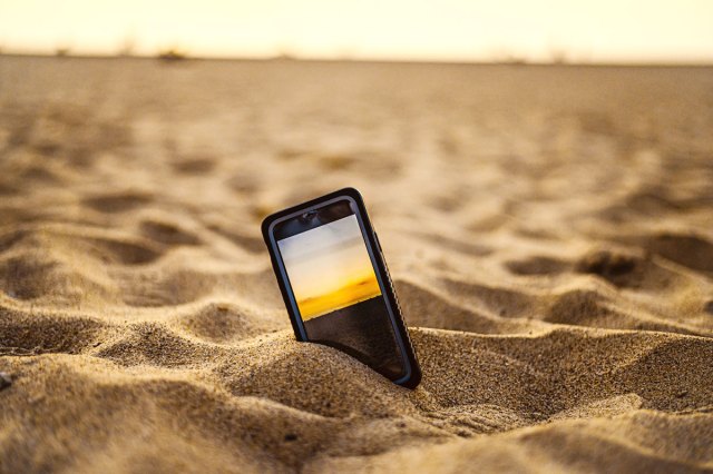 An image of a cell phone in the sand