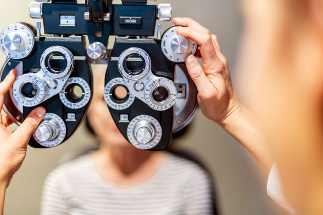 An image of a person getting their eyes checked out by an ophthalmic view vision tester
