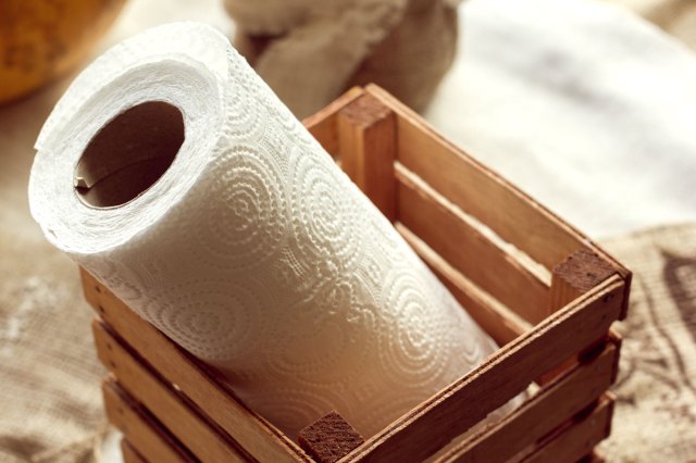 An image of a roll of paper towels in a wooden crate