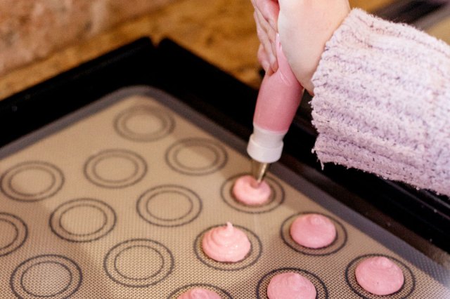 An image of macarons being piped