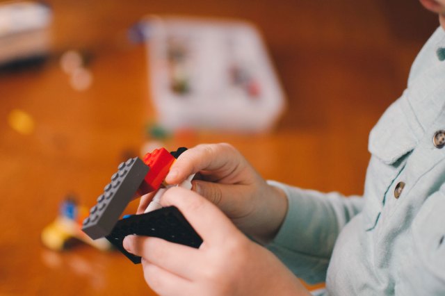 An image of a child playing with LEGO blocks