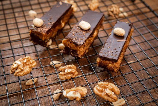 An image of homemade Snickers bars on a wire rack