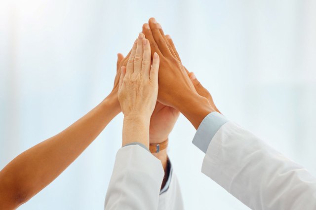 A group of people touching their hands together