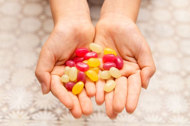 An image of two hands holding jelly beans