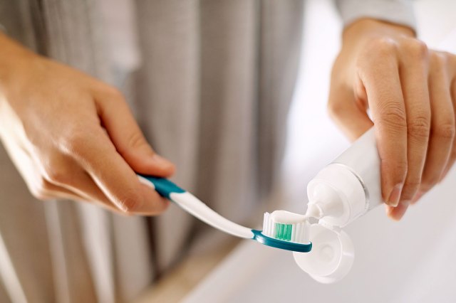 An image of toothpaste being squeezed onto a toothbrush