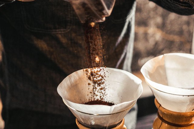 An image of a person pouring coffee grounds into a glass