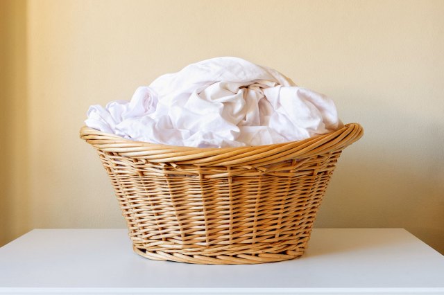 An image of white sheets in a wicker basket