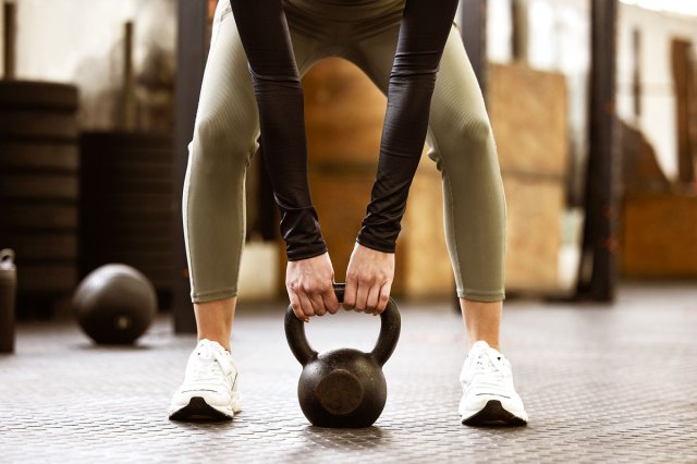 An image of a woman lifting a kettlebell