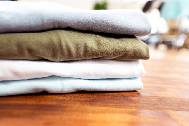 An image of folded shirts on a wooden surface