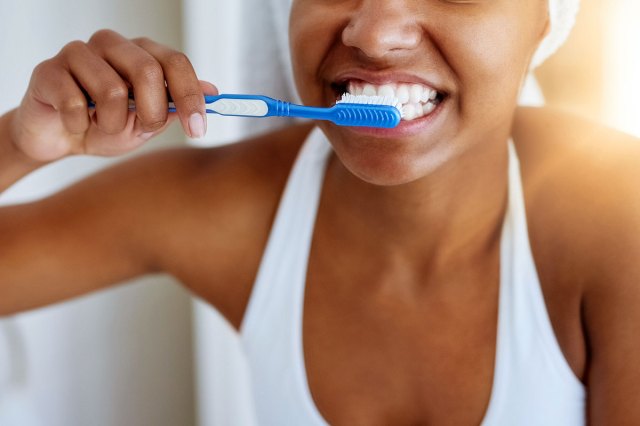 An image of a woman brushing her teeth