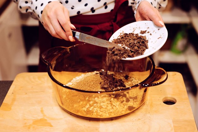 An image of a person pouring chocolate into a mixing bowl