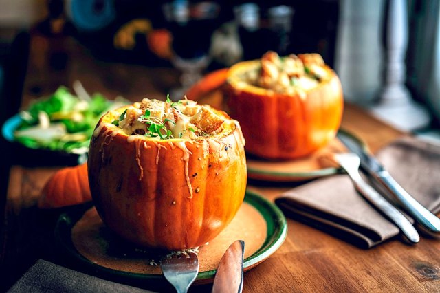 An image of food in pumpkins on a table