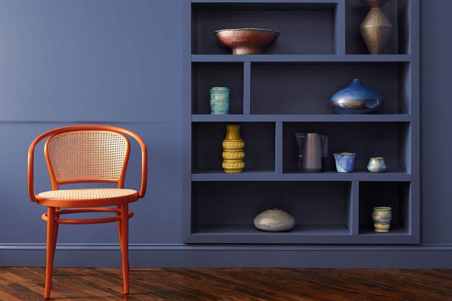 An image of a wall with built-in shelves painted in Blue Nova by Krylon and a chair