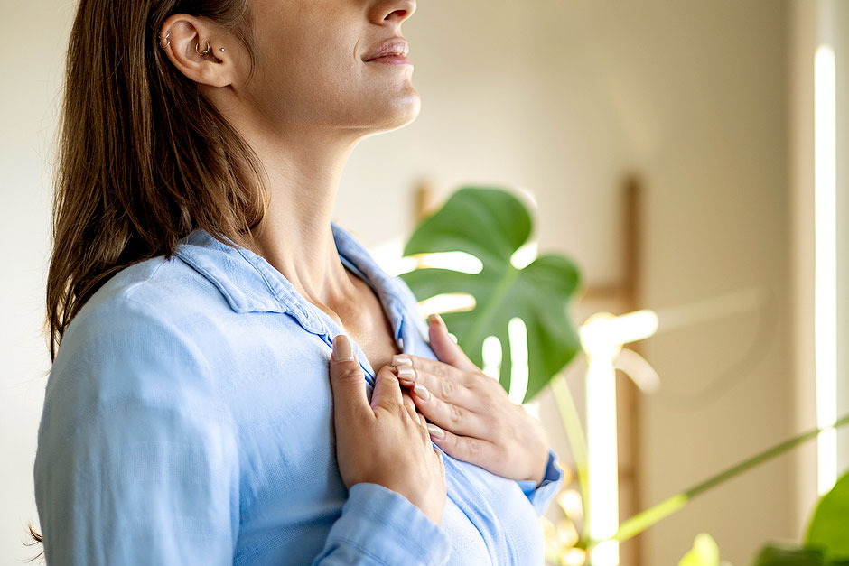 An image of a woman with both hands on her chest