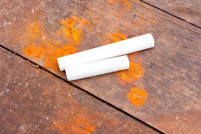 An image of two pieces of chalk on a wooden floor