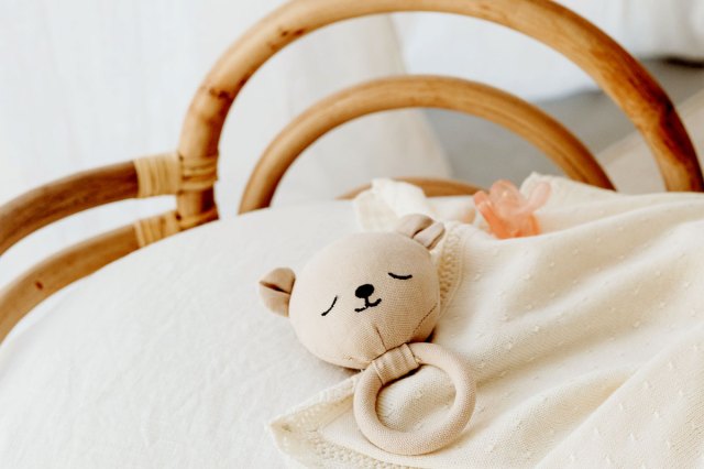 An image of a stuffed bear on a bed
