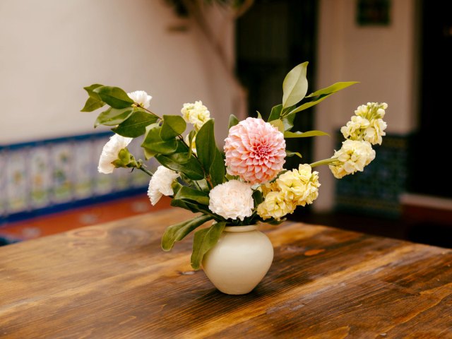 An image of a vase of flowers on a wooden table