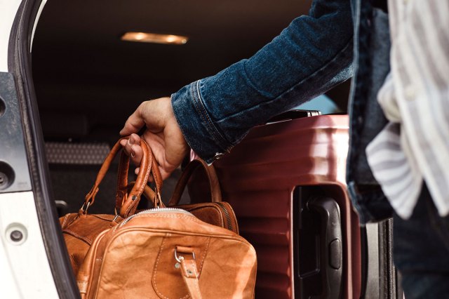 An image of a person taking a duffle bag out of a truck