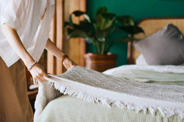 An image of a woman lying a blanket on a bed