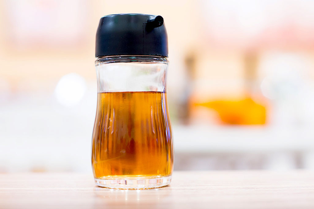 An image of a brown liquid in a clear jar with a black top