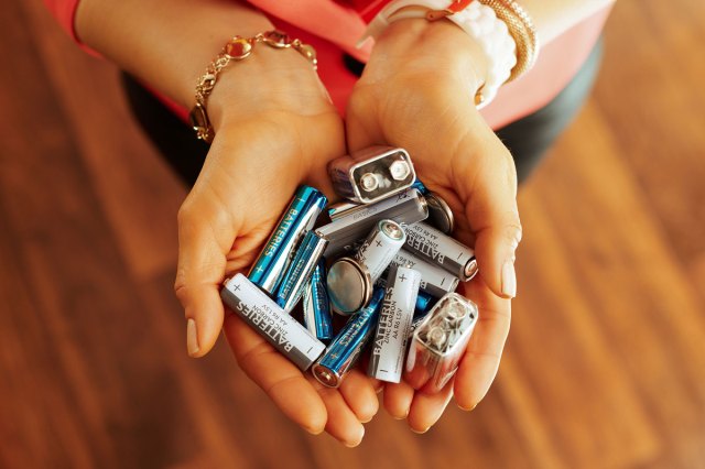 An image of hands holding batteries