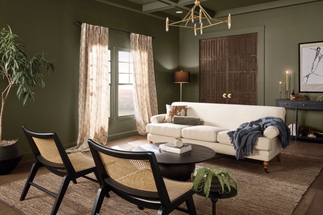 An image of a living room with a white couch, chairs, and a coffee table