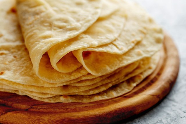 An image of tortillas on a wooden plate