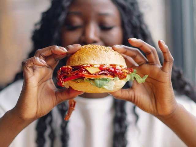 An image of a woman holding a cheeseburger