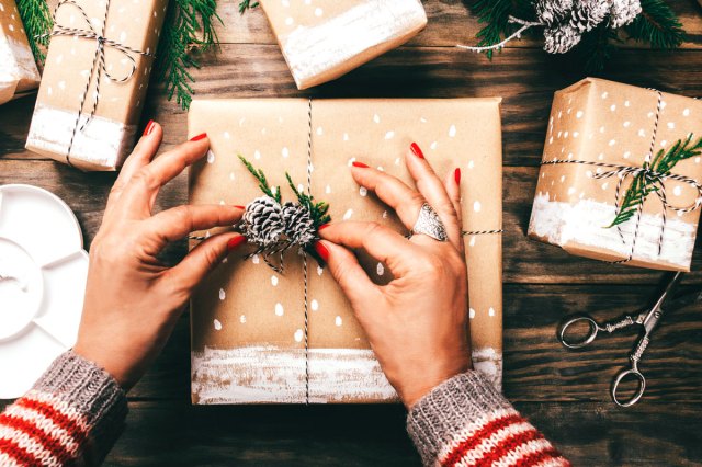 An image of a woman wrapping Christmas presents in a crafty way
