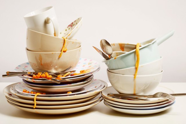 An image of stacked dirty dishes