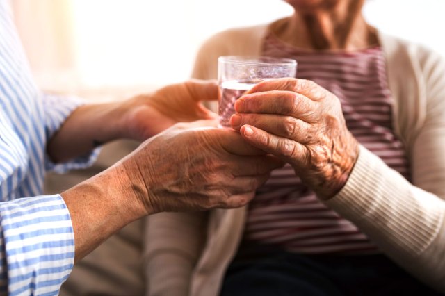 An image of a person handing another person a glass of water