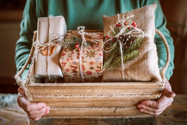 An image of a person holding presents in a wood crate