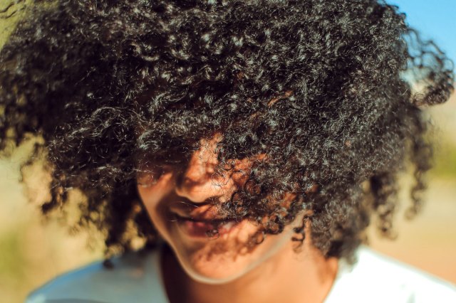 An image of a woman with curly, black hair